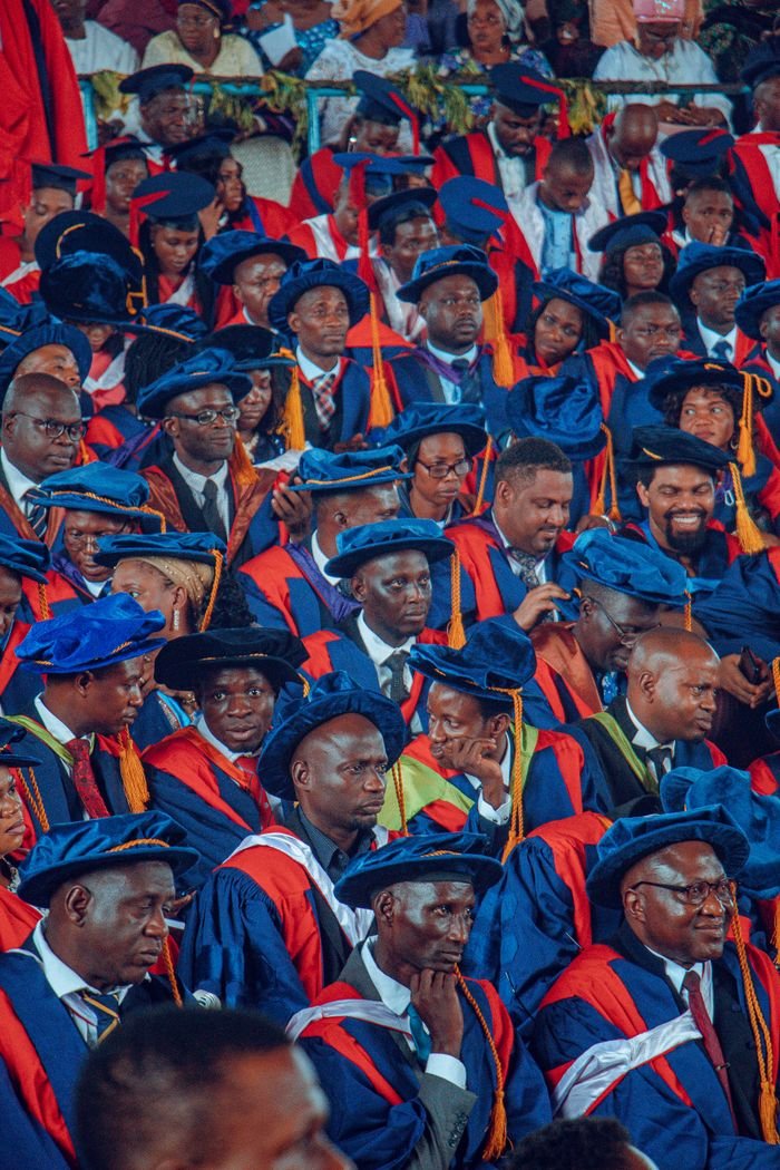 A vibrant graduation ceremony with graduates in colorful academic regalia in Ife, Nigeria.